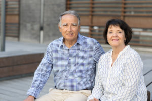 Ett äldre par ler och tittar in i kameran. 
